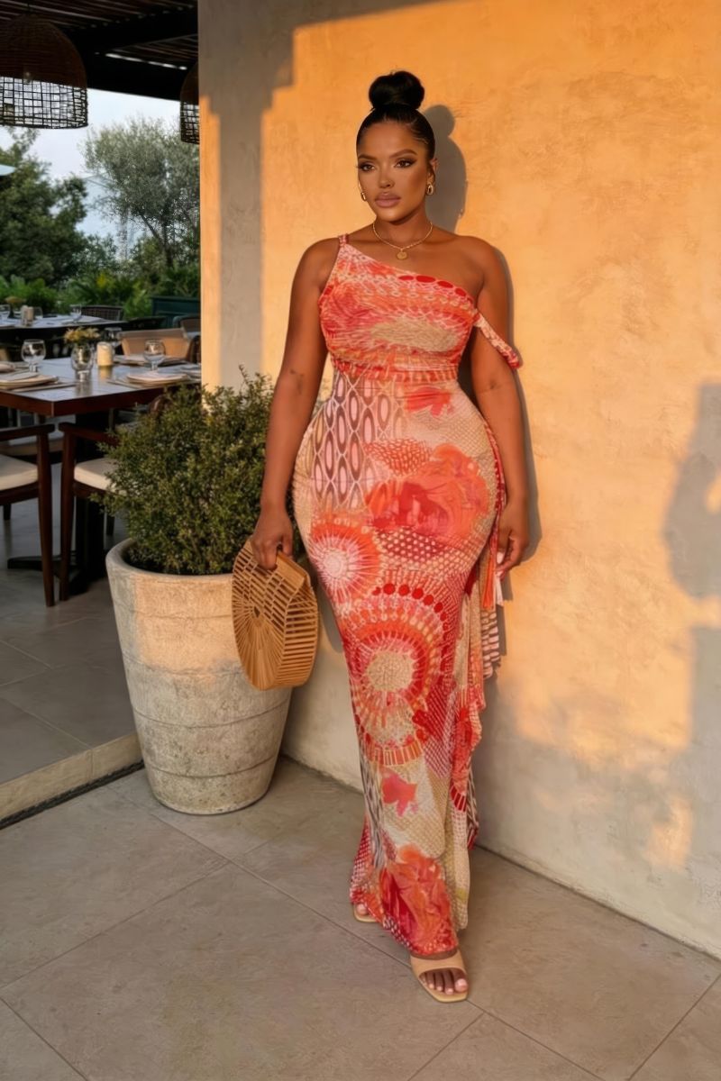Woman in a colorful dress standing next to a wall with outdoor furniture and plants in the background
